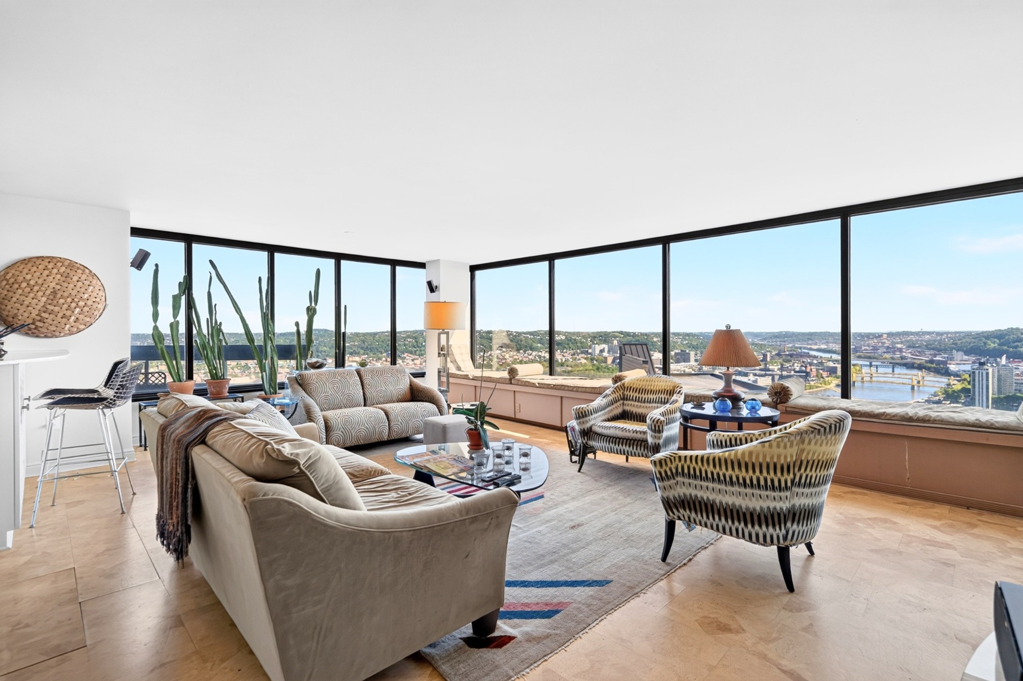 Walls of windows frame Pittsburgh in the corner family room at The Trimont 490E